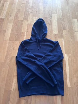 Mörkblå hoodie kom dm för storlek eller frågor! - Snygg mörkblå hoodie från RYVLS Stockholm med klassisk huva och dragsko. Tillverkad i mjukt stickat material som känns skönt mot huden. Perfekt för dig som gillar en enkel och stilren look. Ribbstickade muddar vid ärmslut och nederkant.