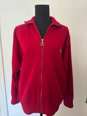 Jättefin röd kofta  - Fin röd kofta som är unisex, storlek M/L, Mindre fläck på nedre delen av koftan synlig i första bilden 