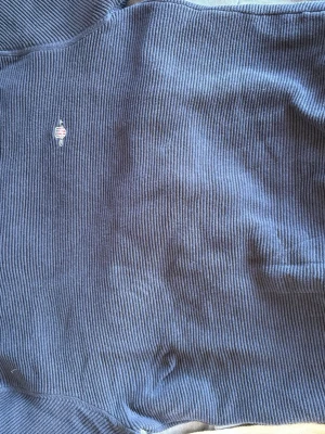 Blå ribbstickad tröja från Napapijri - Mysig blå ribbstickad tröja från Gant med liten broderad logga på bröstet. Tröjan har en klassisk passform och är perfekt för kyliga dagar. Materialet är mjukt och ger en avslappnad vibe.