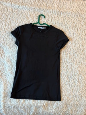Svart tight t-shirt från lager 157 - En enkel och stilren svart t-shirt från Lager 156 med rund hals och korta ärmar. Jag skulle förklara tyget som idrotts tyg🙏🏻💞 pris kan såklart diskuteras