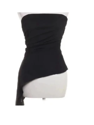 Svart asymmetrisk tubtopp - oanvänd !!‼️‼️💞Säljer en svart tubtopp med asymmetrisk nederkant och draperad effekt. Toppen är axelbandslös och har en stilren, modern look som passar perfekt till olika outfits. Materialet känns mjukt och följsamt mot kroppen.