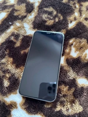 iPhone X  - Säljer en iPhone med stilren svart framsida och rundade hörn. Telefonen har en stor skärm och klassisk Apple-design med glas på framsidan och metallram. Perfekt för dig som gillar snygg och modern teknik , batteriet 100% , nyss skräm baksidan har några streck men den är inte sönder 