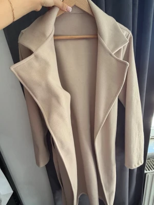 Beige kappa - Säljer min beiga kappa då jag aldrig haft användning för den. Är osäker vart den är köpt eftersom den inte har någon etikett men kan möjligtvis vara missäy. Storlek står inte heller men antagligen S.