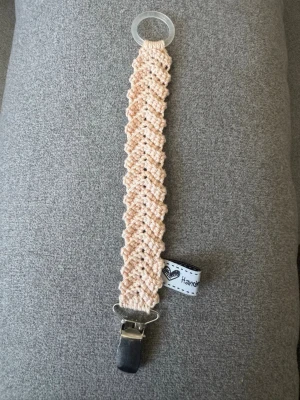 Virkad napphållare - Virkad, ljust aprikosfärgad napphållare, virkad av mig i 100% bomullsgarn med metallclips och silikonring.  Mönsterskapare: animo.design 