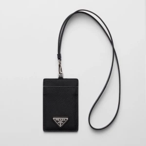 Svart korthållare  - Snygg svart korthållare i läder med struktur och klassisk trekantig logga i metall framtill. Praktisk rem för att bära runt halsen och ett fack för kort. Perfekt accessoar för dig som vill ha koll på dina kort med stil.