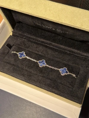 Van Cleef & Arpels pietersite 5 motif armband - Van Cleef & Arpels pietersite 5 motif armband doppat (tjockt lager) vitt guld med riktig stenar (inte i plast som flesta VCA armband). Säljer då den inte kommer till användning. Gjord på beställning. Minimalt använd. Kommer med förvarings-låda och ytterförpackning. 