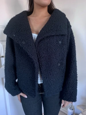 Mörkblå Teddy jacka  - Svart, mjuk teddyjacka med struktur och lite oversized passform. Dubbelknäppt med knappar framtill och bred krage som ger en stilren look. Perfekt som lättare jacka eller kofta till både vardag och höstlager💞💞