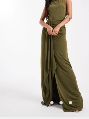 Olivgrön långklänning med drapering - Snygg olivgrön långklänning med draperad midja och slits framtill. Klänningen har ärmlös design och rund halsringning, vilket ger en elegant och modern look. Perfekt för dig som vill sticka ut med stilrena detaljer. Lappen kvar! 