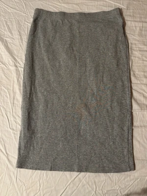 Grå rak kjol i bomull - En enkel och stilren grå kjol med rak passform. Är i storlek L men sitter mer som en M om man vill ha den tajt och S om man vill ha den lite lös nere vid benen.