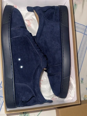Mörkblå mockasneakers från Lethal - Stilrena sneakers i mörkblå mocka från Lethal. Skorna har en låg profil, matchande mörkblå snörning och diskreta sömmar. Yttersulan är också mörkblå och insidan är ljusbeige. Perfekta för en clean och modern look.