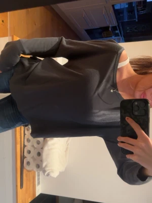 Mörkgrå långärmad tröja - En basic mörkgrå långärmad tröja med rund halsringning. Tröjan har en avslappnad passform och är tillverkad i ett mjukt och tunt material, perfekt för lager-på-lager. Enkel och stilren design som funkar till det mesta.