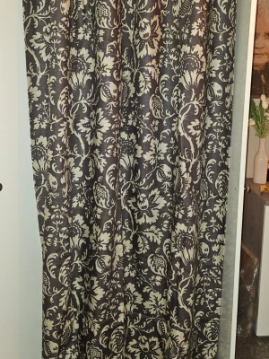 Mörkbruna gardinlängder med blommönster - Säljer två mörkbruna gardinlängder med stort, beige blommönster. Tyget är tjockt och har en klassisk, elegant känsla. Perfekt för att ge rummet en mysig och stilren look. Passar bra till både vardagsrum och sovrum. Ganska tungt tyg så kan ibland hoppa ur ngn öljett men lätt att knäppa dit igen.