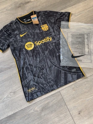 Nike FC Barcelona - FC Barcelona bortatröja 23/24, storlek M. Ny med tags. Stilren svart design med gula detaljer, Nike-logga och Spotify-sponsor.
