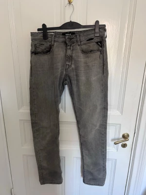 Snygga gråa Jeans från Replay - Riktigt schyssta gråa jeans från Replay med estetiska slitningar vid fickor. De är i storlek 30 och sitter perfekt tajta.