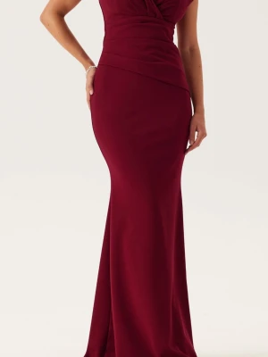 Vinröd långklänning med omlottliv - Säljer en elegant vinröd långklänning med omlottliv och figurnära passform. Klänningen har en v-ringad urringning och är ärmlös, vilket ger en stilren och festlig look. Perfekt för bal eller andra speciella tillfällen. Med prislapp kvar. 