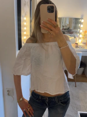 Vit offshoulder blus med puffärm - Snygg vit offshoulder blus med puffiga trekvartsärmar och lätt rynkad kant upptill. Blusen är croppad och har en luftig känsla, perfekt till jeans eller kjol. Älskar denna till sommaren!🥰