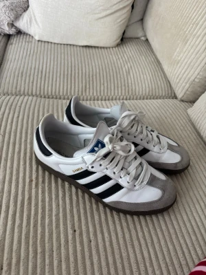 Adidas Samba vita och svarta sneakers - Klassiska Adidas Samba sneakers i vitt och svart. Sparsamt använda och passar till allt