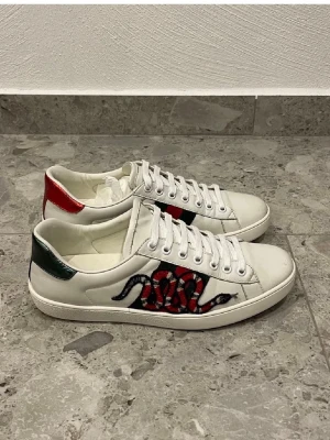 Gucci vita sneakers med orm - Säljer ett par vita gucci ace skor. Bra skick, kommer inte med något og. Pris 1699 men vid snabb affär går att pruta.
