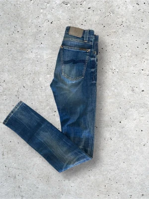 Blå slim fit jeans från Nudie Jeans - Säljer ett par blå slim fit jeans från nudie jeans. Storleken är w26 l32. Hör av er vid funderingar. (Priset är ej hugget i sten). 