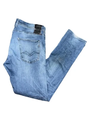 Replay hyperflex Grover jeans  - Säljer ett par Replay Grover jeans i ljusblå tvätt med klassisk femficksdesign och snygga slitningar. Jeansen har raka ben och normal passform, med Replay-logga på bakfickan och läderpatch i midjan. Perfekta för dig som gillar en avslappnad stil. Midja 45cm, längd 107cm OBS, jeansen har fläckar som syns på en utav bilderna och även har lite fåll alltså slitningar längst ned på benen på baksifan :)