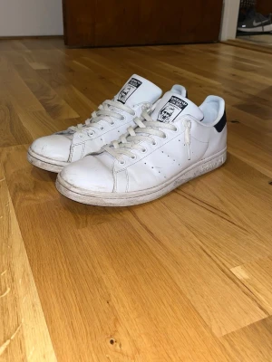 Adidas Stan Smith - Vita Adidas Stan Smith sneakers med marinblåa detaljer på hälen. Perfekta till våren!