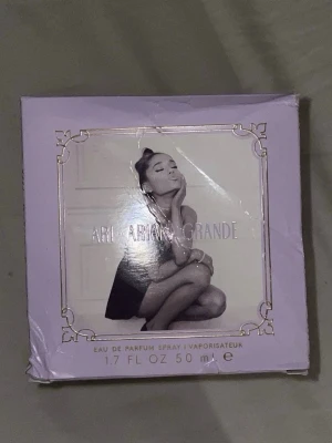 Ari Eau de Parfum från Ariana Grande - Ari Eau de Parfum från Ariana Grande, 50 ml. Flaskan är kristallformad med en transparent design och har en silverfärgad kork samt en vit fluffig pompom. Doften är feminin och modern, perfekt för dig som gillar fruktiga och söta parfymer.