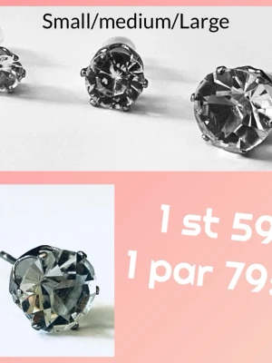 Silvriga örhängen med stora stenar - Snygga örhängen i silverfärg med stora, gnistrande stenar i tre olika storlekar. Perfekta för att ge din look lite extra bling. Klassisk design med rund form och metallinfattning.