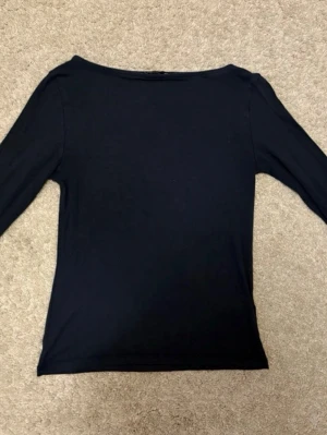 Marinblå  långärmad topp - En enkel och stilren marinblå långärmad topp med rak passform och båtringad hals. 