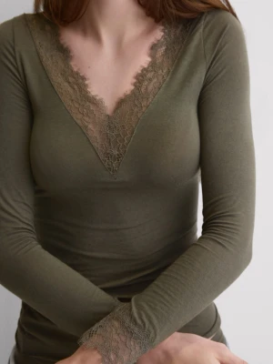 Intimissimi olivgrön topp med spetsdetaljer storlek small, ny!  - Olivgrön långärmad topp med djup v-ringning och spetsdetaljer vid halsringning och ärmslut. Tunn och mjuk kvalitet som sitter snyggt på kroppen. Perfekt för dig som gillar en feminin och stilren look. Ny med lapp från Intimissimi.
