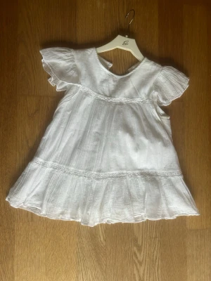 Vit volangblus med korta ärmar - Söt vit blus i tunn, luftig bomull med volangdetaljer, säljer då den är för liten för mig!💗 Perfekt för en somrig och avslappnad look! Är lite missfärgad i armhålan men inget som syns när man använder den!💗