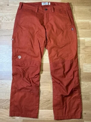 Fjällräven G-1000 Nilla trousers - Fjällräven G-1000 Nilla-byxor i storlek M. Tillverkade av det ikoniska G-1000-tyget, känt för sin hållbarhet och funktionalitet.  Perfekt för vandring, utomhusaktiviteter, resor eller vardagsbruk. Praktisk design med en ren skandinavisk look, lätt att styla med friluftsjackor, tröjor eller vardagstoppar.  Om du har några frågor om bilder eller mått, tveka inte att kontakta mig.  