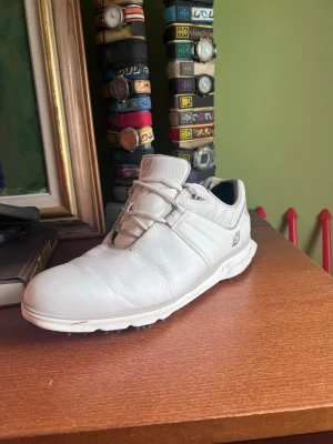 Vita golfskor från FootJoy - Snygga vita golfskor från FootJoy. De är i storlek 43 och används fåtal gånger, de är i mycket bra skick. Hälskydden på hälen är för extra mjukhet men går att ta bort om man vill.