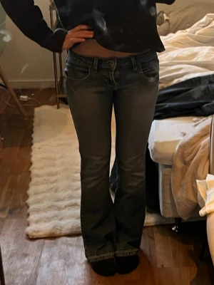 Blå bootcut jeans med låg midja från Lee - Säljer ett par blå bootcut jeans med låg midja och snygga detaljer på bakfickorna. Jeansen är ifrån Lee och är i storlek 25💞💞