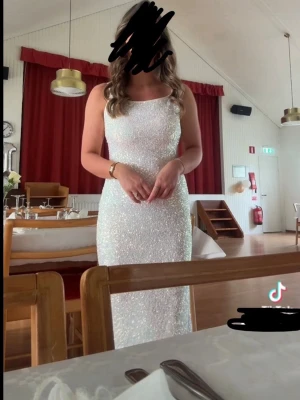 Balklänning  - Supersnygg vit långklänning med glittrigt tyg och smala axelband. Klänningen har öppen rygg med snörning och en figurnära passform. Perfekt inför balen💕köpte klänningen för 1500 men säljer för 849kr (Priset går att diskutera🥰). Jag är 162 cm lång + hade klackar som var ca 7 cm höga och klänningen går hela vägen ner till golvet. Använd en gång och är i väldigt bra skick! Klänningen är kemtvättad! 