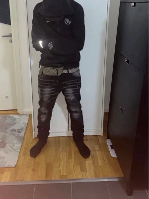 Svarta skinny jeans med slitningar - Säljer ett par svarta skinny jeans med slitningar och vita färgstänk. Jeansen har en tight passform, detaljerade slitningar på knäna och ljusa tvätteffekter över låren. Perfekta för en streetwear-look.