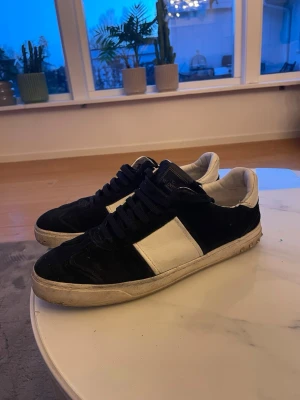 Valentino flycrews - Snygga sneakers från Valentino i svart mocka med vita detaljer och vit sula. Klassisk låg modell med svarta skosnören och vit insida. Perfekta för dig som vill ha en stilren och trendig look. Alla nitar finns kvar. INGA BYTEN