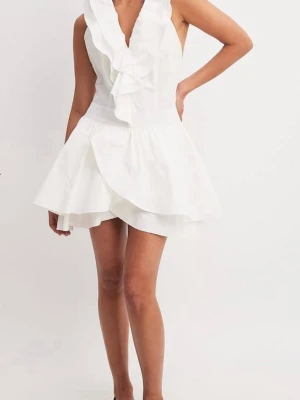 Vit omlottklänning med volang - Supersöt vit kortklänning med omlottdesign och volangdetaljer framtill. Klänningen är ärmlös och har öppen rygg, vilket ger en fräsch och somrig känsla. Perfekt för varma dagar och speciella tillfällen. Perfekt för midsommar eller studenten. Prislapp sitter kvar, oanvänd.