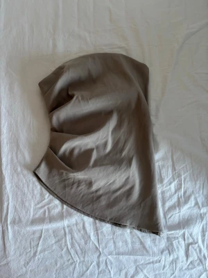 Beige tubtopp - Säljer en beige tubtopp, perfekt till i sommar eller på fest! Fint skick utöver lite tråddragning som inte märks av.