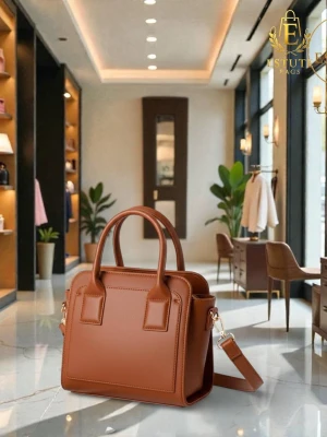 Brun handväska i läderlook - Snygg brun handväska från Estuti Bags i stilren design. Väskan har två rejäla handtag och en avtagbar axelrem. Tillverkad i material som liknar läder och har en boxig, strukturerad form. Perfekt för dig som gillar klassisk men trendig stil.