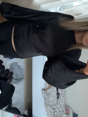 Svart satinblus  - Stilren svart blus i glansigt från Nelly jätte fin bara andvänd 1 gång