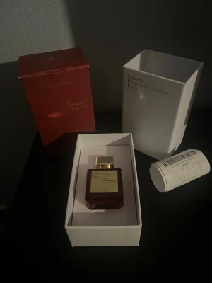 Maison Francis Kurkdjian Baccarat Rouge 540 Parfym - Lyxig parfym i elegant röd glasflaska med guldfärgat lock från Maison Francis Kurkdjian. Doften Baccarat Rouge 540 kommer i en exklusiv förpackning med både röd och vit kartong, samt dekorativt mönster på ytterkartongen. Perfekt för dig som gillar exklusiva dofter.