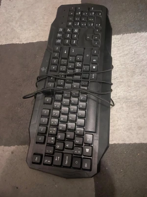 Svart USB-tangentbord - Säljer ett svart tangentbord med USB-anslutning. Tangentbordet har fullstora tangenter, numerisk del och klassisk layout. Tillverkat i plast och har en robust design med tydliga vita tecken på knapparna. Perfekt till datorn för gaming, plugg eller jobb.