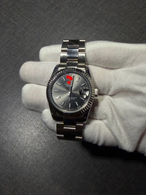 Klassisk silverfärgad klocka - Stilren klocka i silverfärgat rostfritt stål med länkarmband och rund urtavla. Urtavlan är grå med tydliga indexmarkeringar och datumfönster. Perfekt accessoar för dig som gillar tidlös design och exklusiv känsla.