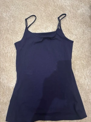 Mörkblå linnetopp från Anna Field - Snygg mörkblå linnetopp från Anna Field med tunna axelband och enkel, stilren design. Perfekt att matcha med jeans eller kjol för en clean look. Tillverkad i mjuk bomull som känns skön mot huden.