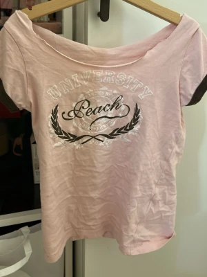 Ljusrosa t-shirt Peach University - Kragen är dåligt klippt