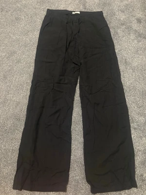 Svarta linnebyxor från stradivarius - Säljer ett par svarta linnebyxor från stradivarius i storlek S. Byxorna har rak passform, resår i midjan och är tillverkade i ett lätt och luftigt linnematerial.