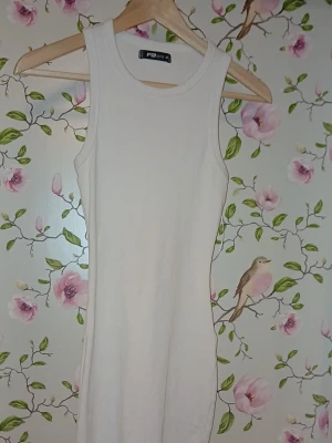 Vit ribbad ärmlös klänning F&b - Säljer en enkel och stilren vit ribbad klänning från F&b. Klänningen är ärmlös med rund halsringning och har en kroppsnära passform. Perfekt för dig som gillar minimalistisk och clean stil.