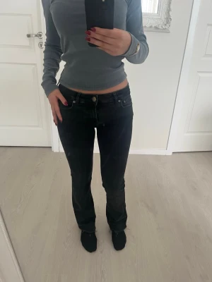 Svarta bootcut jeans med låg midja - Säljer ett par svarta bootcut jeans med låg midja. Jeansen har en snygg tvätt och sitter jättefint. Perfekta till vardagsstilen och passar till det mesta. Färgen skiftar till grå. Köpta för 499kr