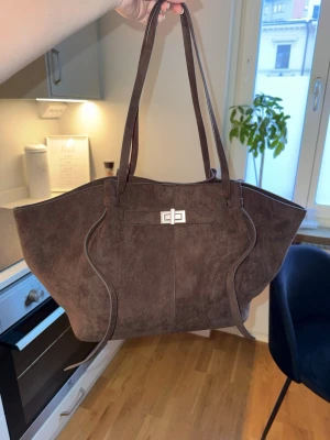 Väska  - Den stora modellen ”long strap bag” från GinaTricot i mockaliknande material. Den är använd men fortfarande i fint skick, finns några fläckar inuti väskan som säkerligen går att få bort men bilder finns på detta i dem sista bilderna av annonsen 🌸