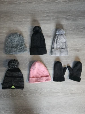 5 stycken mössor och ett par vantar i nyskick  - Säljer en svart och gråmelerad Adidas som är stickad i mjukt material. Perfekt för kalla dagar och sportiga outfits. Den rosa är en Peak Performance mössa. Den svarta och gråa mössorna har mjukt fleecetyg inuti. Den gråa mössan utan tofs är varm och skön. Vantarna är fodrade. och är storlek 7-8. Adidas mössan och Peak Performance mössan är sparsamt använda och de andra mössorna är oanvända. Storlek på mössorna är 52-56 då de är väldigt streachiga. Skriv gärna om du har några frågor.